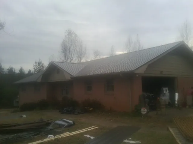 Gray metal roof on a stucco house with an attached garage in Cordova