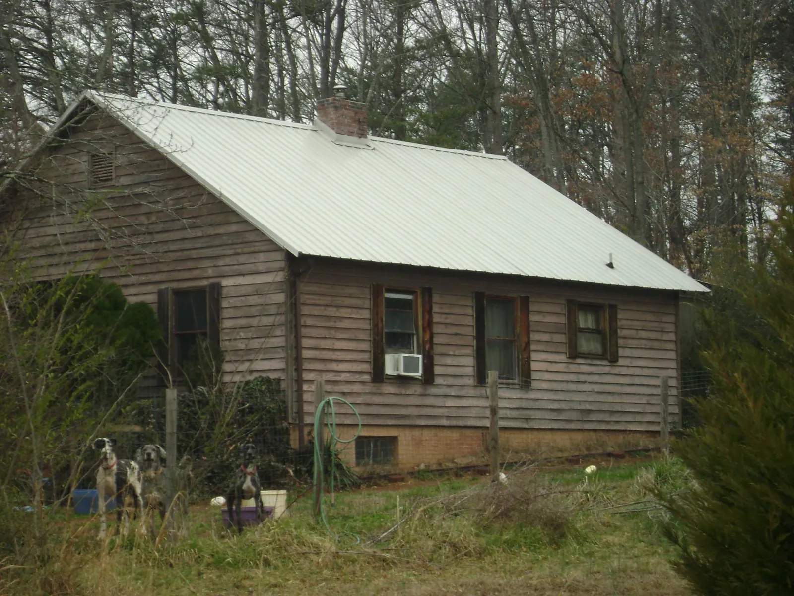 White metal roof on an old wood sided farmhouse, from a Metal Roof Installation job in Cordova